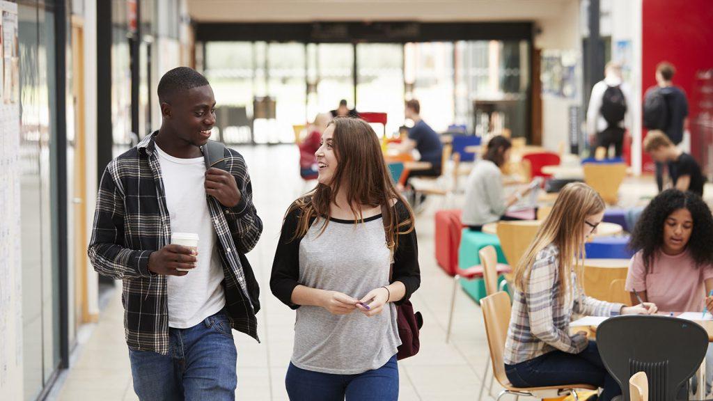 Communal Area Of Busy College Campus With Students